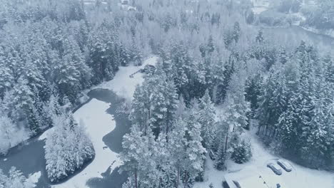 Cinematic-aerial-shot-of-beautiful-winter-landscape-in-the-mountains-with-trees-and-houses-covered-with-snow