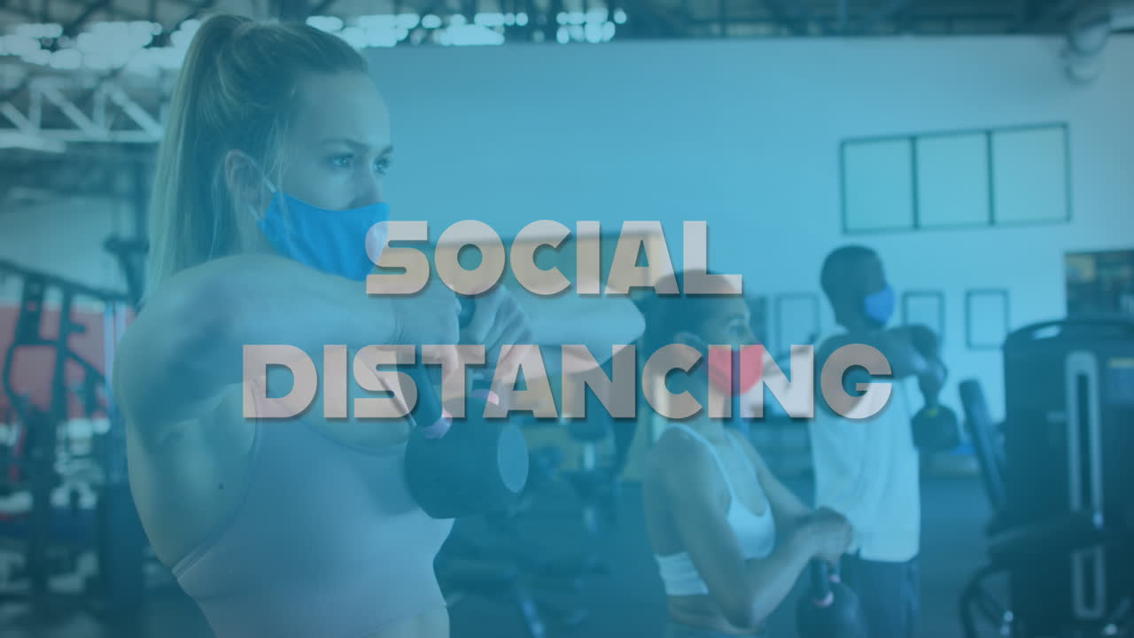 Animation of words social distancing over diverse group wearing face masks working out
