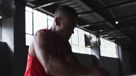 african american man exercising battling ropes in an empty urban building