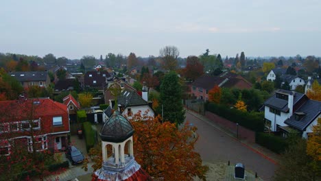 beautiful dolly of an old crucifix overlooking a small town on a overcast autumn day
