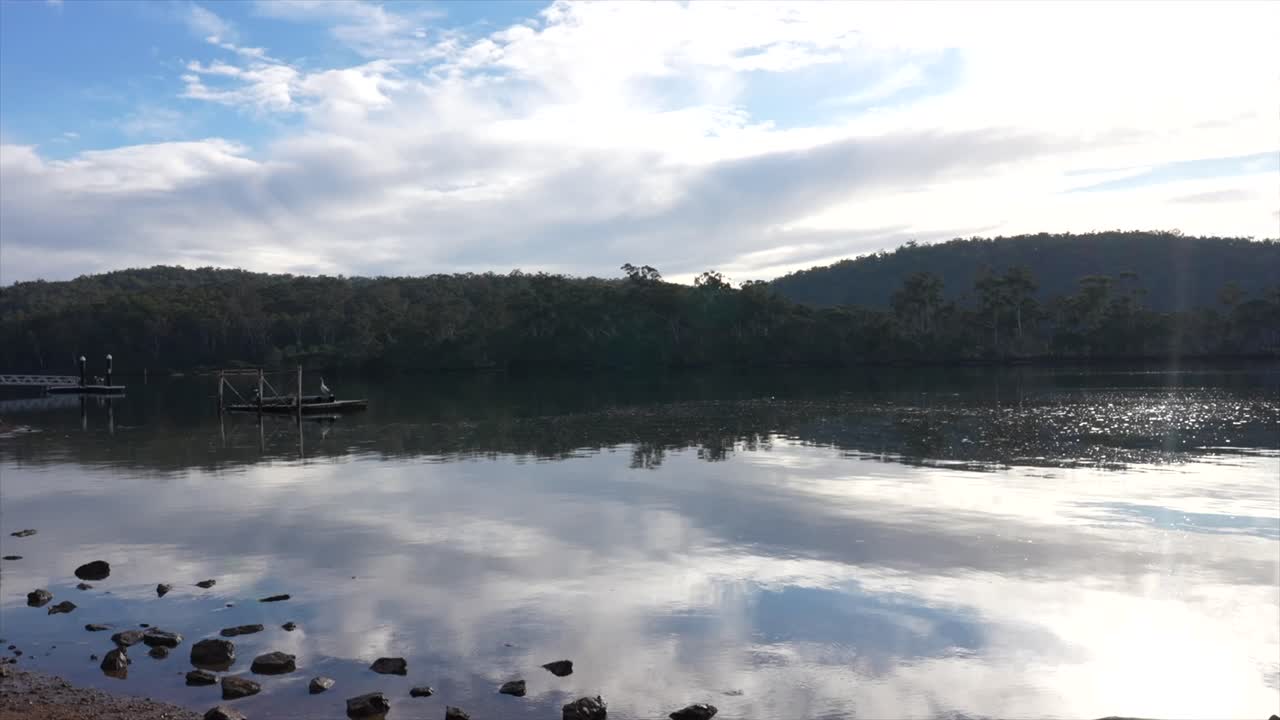 Pambula lake calm and still reflecting the clouds in the sky, New South Wales, Australia