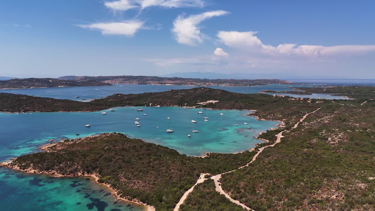 Peaceful Sardinia lagoon with yachts, clear skies, and beautiful coastline