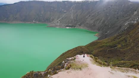 orbital drone shot overlooking the quilotoa lake in ecuador with scenic views from a viewpoint