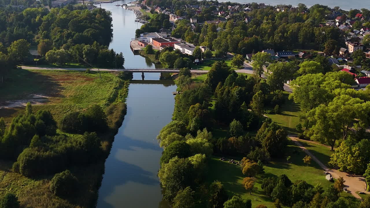 Luftoptagelse af sommerhuse ved Østersøens skovklædte landskab i Pavilosta, Letland.