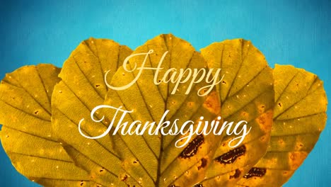 Animation-of-happy-thanksgiving-text-over-autumn-leaves-on-blue-background