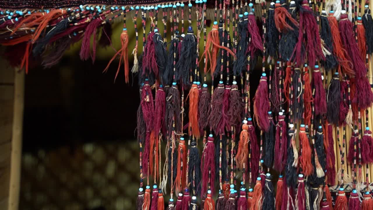 Red wool tassels decorate the doorway of a traditional yurt in Turkmenistan