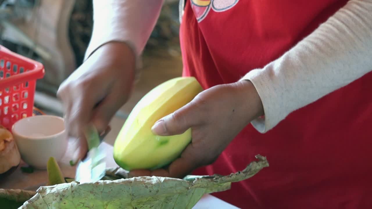 Cena em câmera lenta de fruta sendo descascada em uma aula de culinária Khmer no Camboja