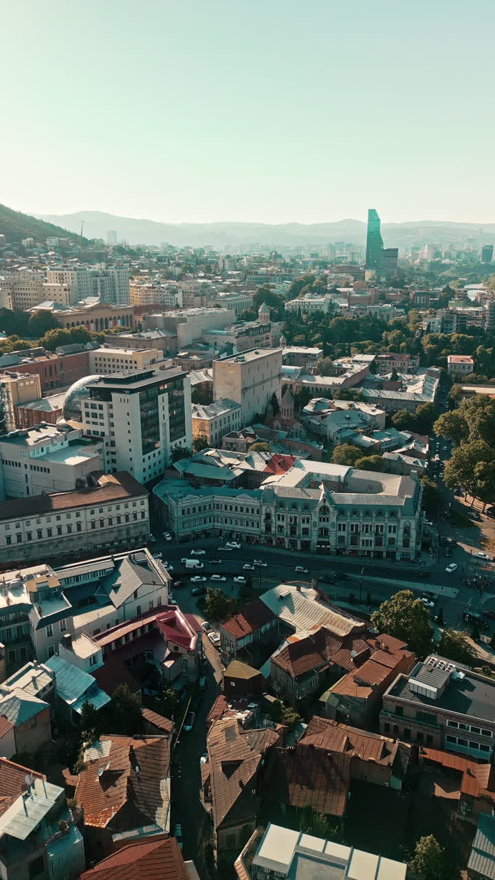 Panoramic Aerial View of a Vibrant Cityscape with Diverse Architecture and Distant Mountains