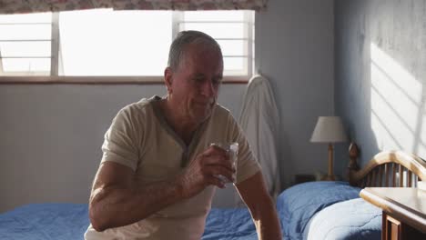 hombre mayor bebiendo agua en casa