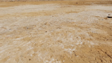 el agua salada evaporada deja crestas y marcas blancas en la arena del mar muerto.