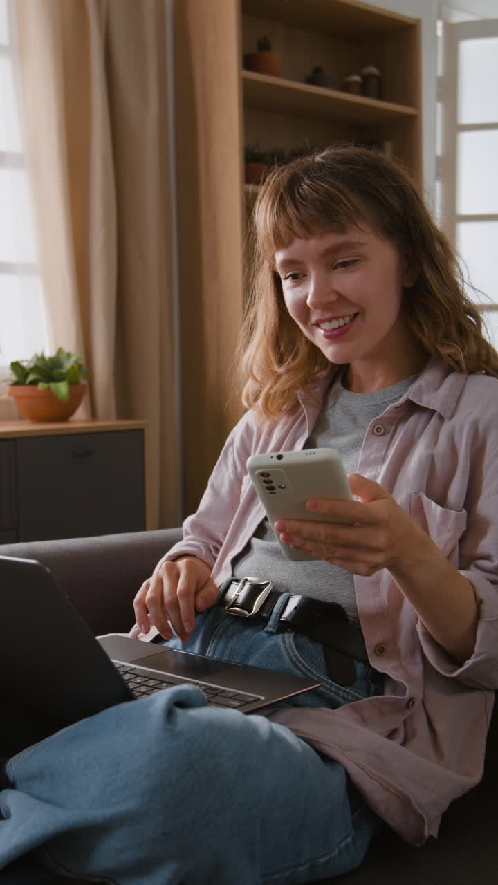 Donna che usa laptop e telefono cellulare a casa