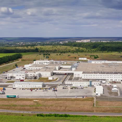 industry on field. large territory of industrial plant on green nature background under blue sky. manufacturing in rural place. aerial view