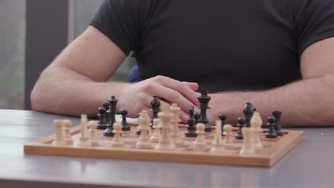 a man is playing chess at a kitchen table