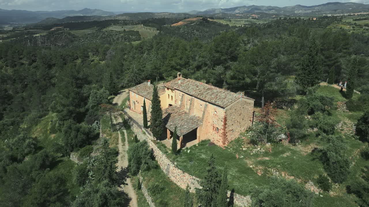 Aerial view of the catalan hermitage mare de deu de pinyeres, a historical sanctuary nestled amidst a serene landscape of lush greenery and rolling hills in el priorat, catalonia