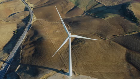 Vista-Aérea-De-La-Turbina-Eólica,-Sobrevuelo-Dinámico-Y-Vista-Giratoria-De-La-Energía-Eólica-Desde-Arriba,-Toma-Muy-Interesante-Al-Atardecer-En-4k