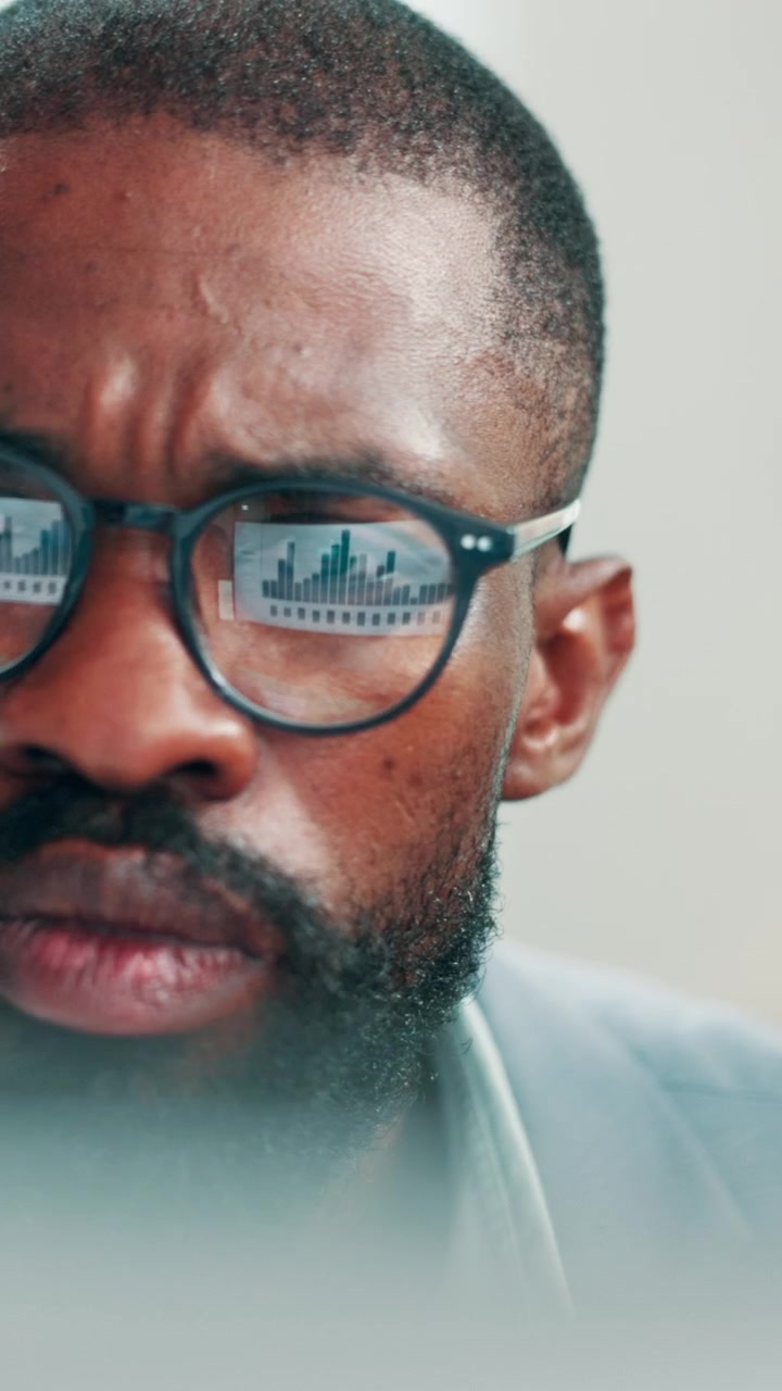 Focused Businessman Analyzing Financial Data on Computer Screen