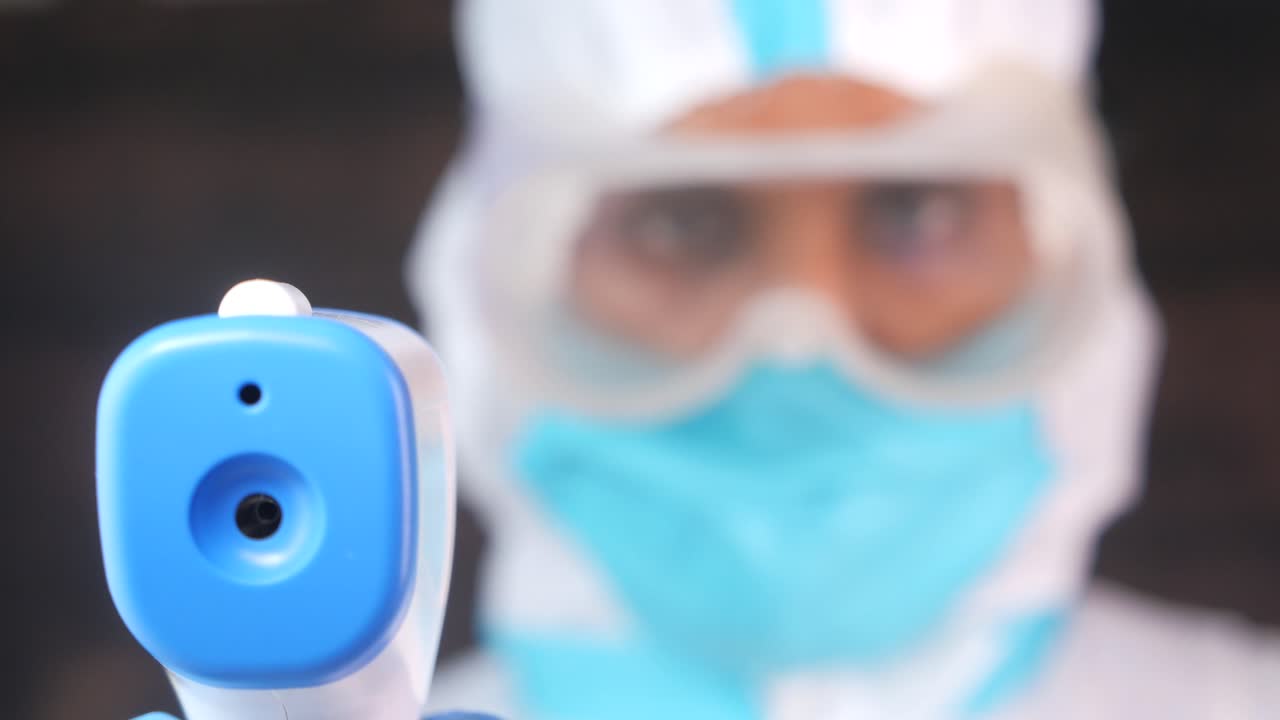 접촉 없는 온도계를 사용하는 의료 종사자