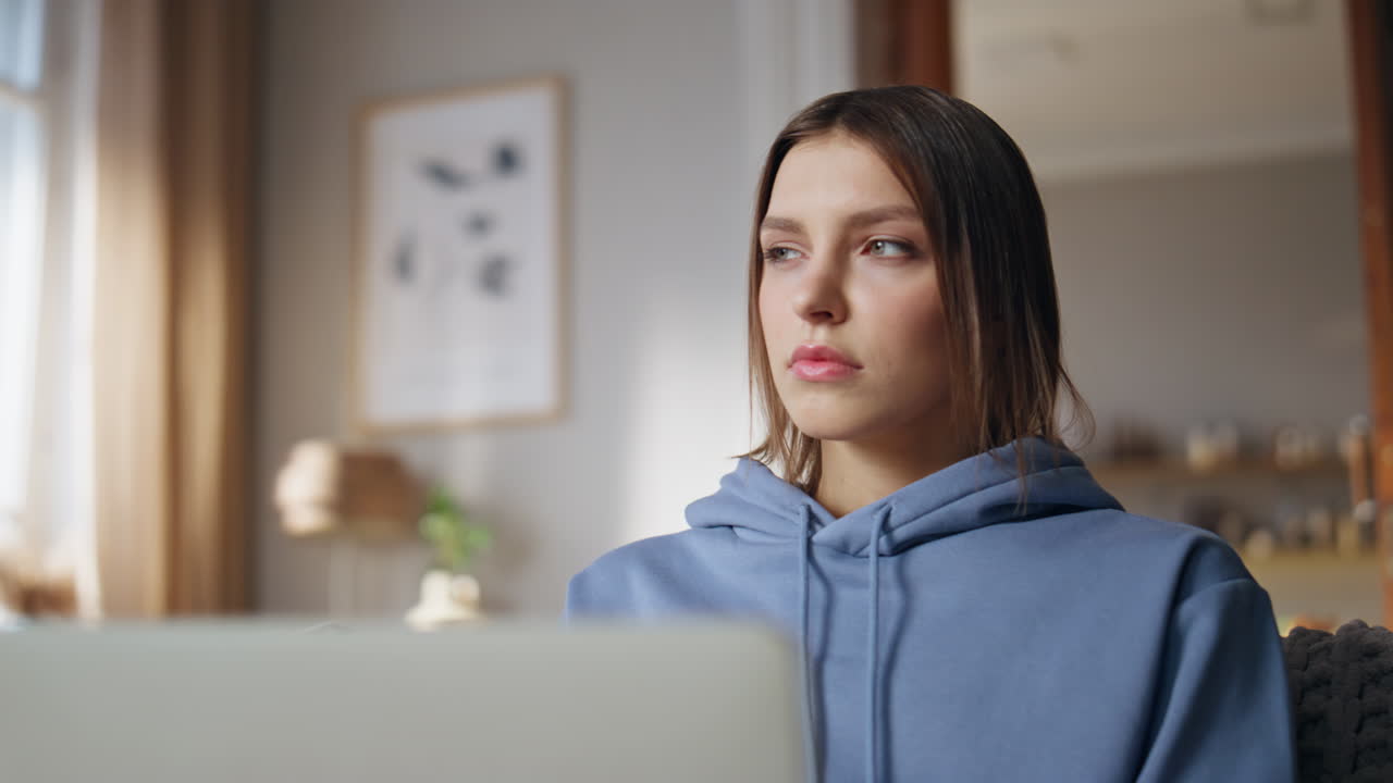 una mujer con capucha usando una computadora portátil