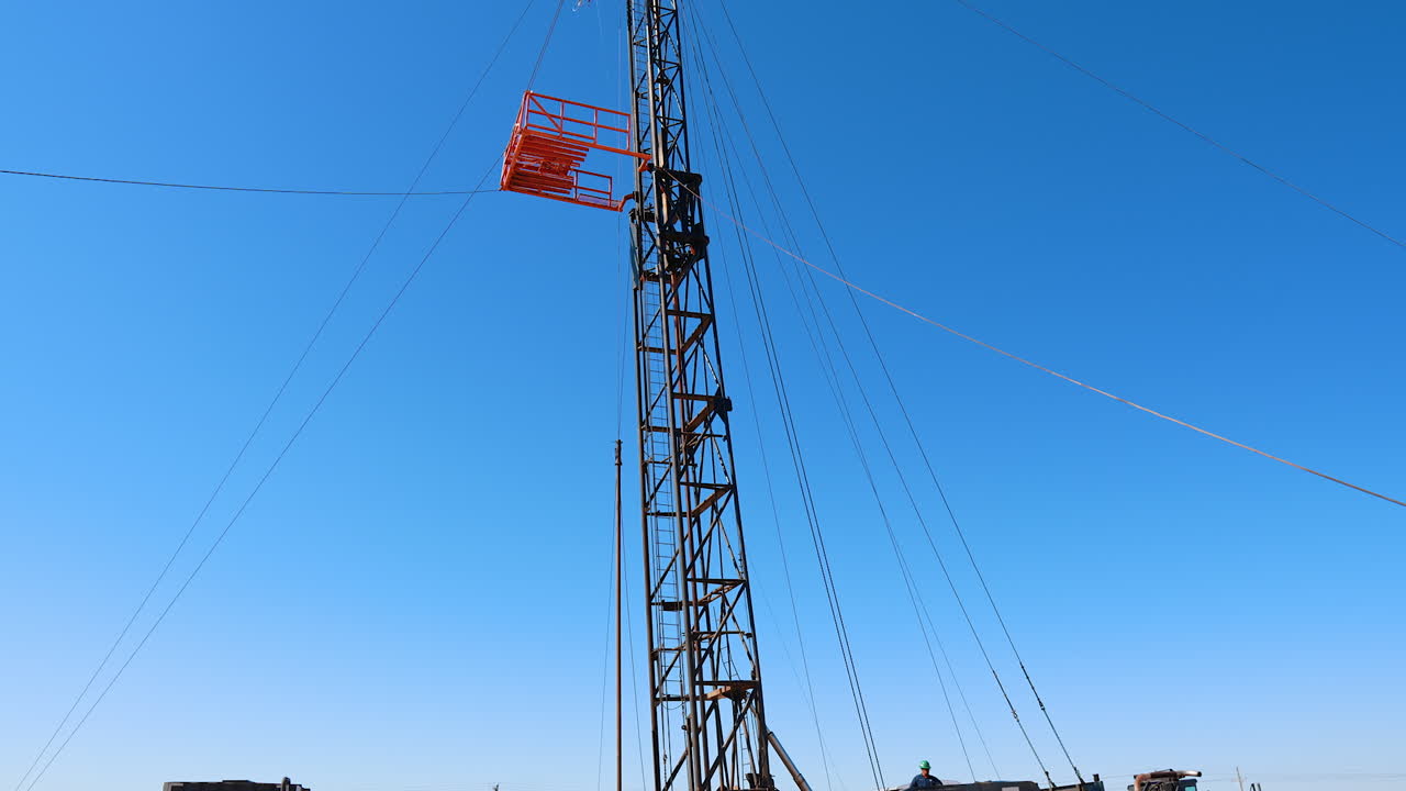 A little site in the desert for oil or gas production. A truck with a huge metal tower on is set to drill the resources.