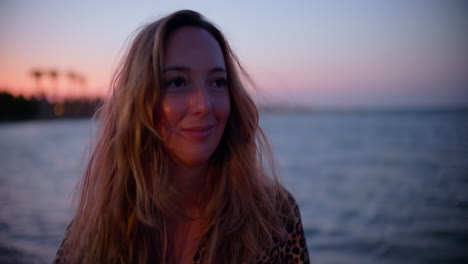 Closeup-of-a-beautiful-young-woman-on-the-windy-beach-at-sunset