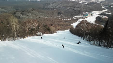 驚くべき山の景色に囲まれて 雪で覆われた斜面を ⁇ るスノーボード選手を 撮影した