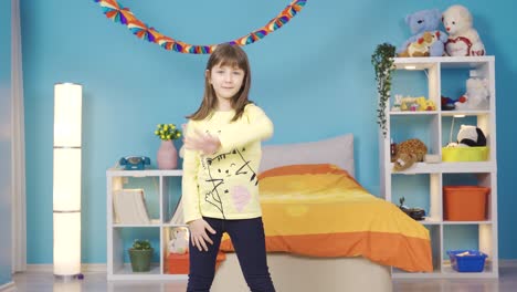 cute little girl is dancing wildly in her colorful modern room.