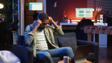 vertical video male freelancer multitasking at home solving tasks with music on headset