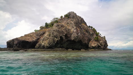 Castaway-Qalito-Malolo-Island-Tourism-Fiji-boat-ride-sailboat-Roro-Reef-coral-white-sandy-shores-rocky-boulder-hillside-tropical-palm-tree-paradise-Mamanuca-group-breezy-sea-nature-landscape-slow-zoom