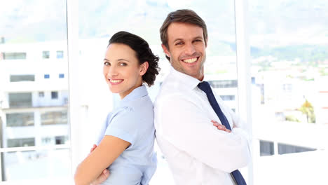 smiling business partners standing back-to-back