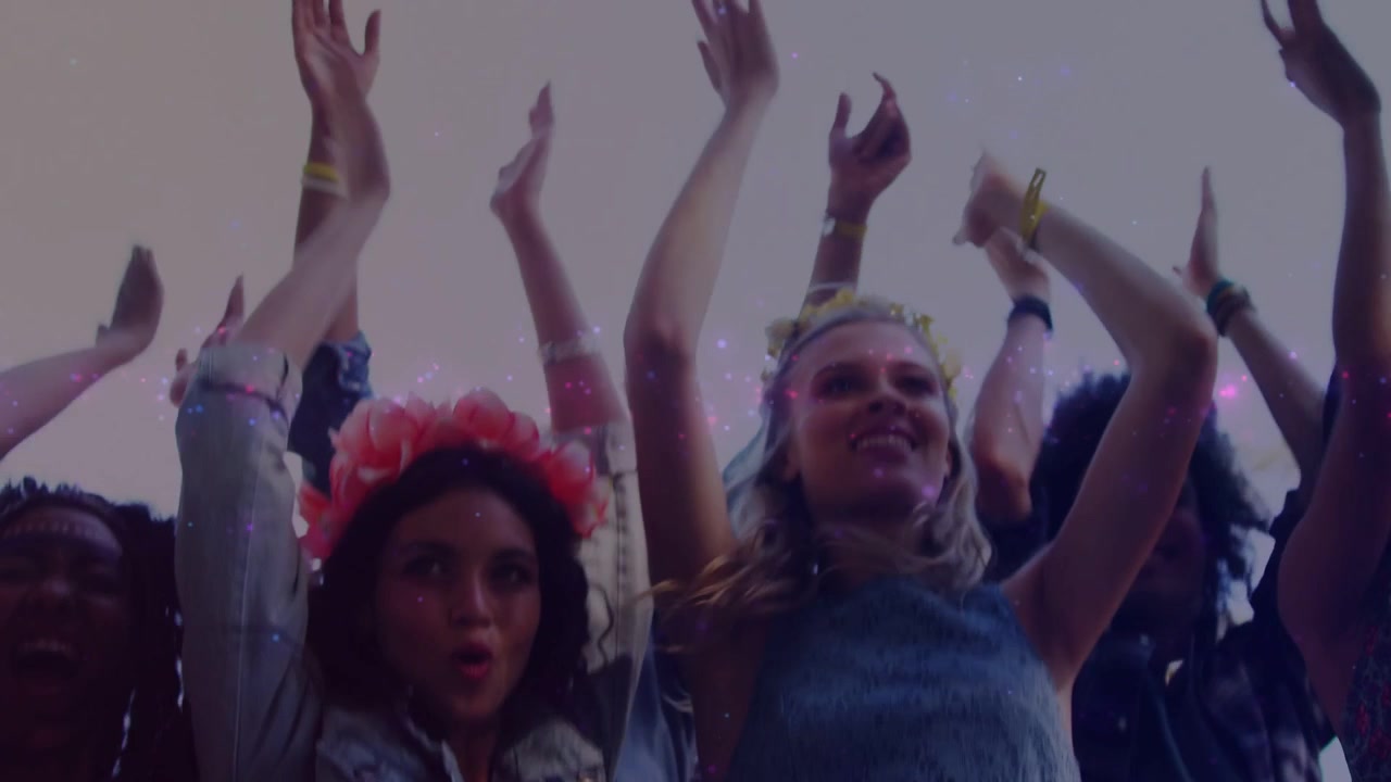To kvinder, den ene med blomsterkrans, på festival, rytmen starter, klapper, glimmer bevæger sig over armene