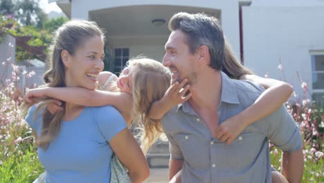 padres encantadores dando cerdo de vuelta a sus hijas