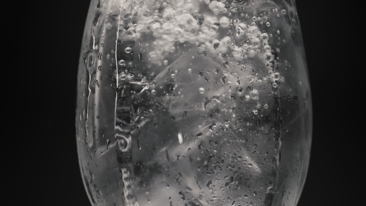 agua con burbujas de hielo dentro del vidrio de primer plano. cócteles y bebidas concepto