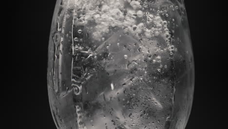 agua con burbujas de hielo dentro del vidrio de primer plano. cócteles y bebidas concepto