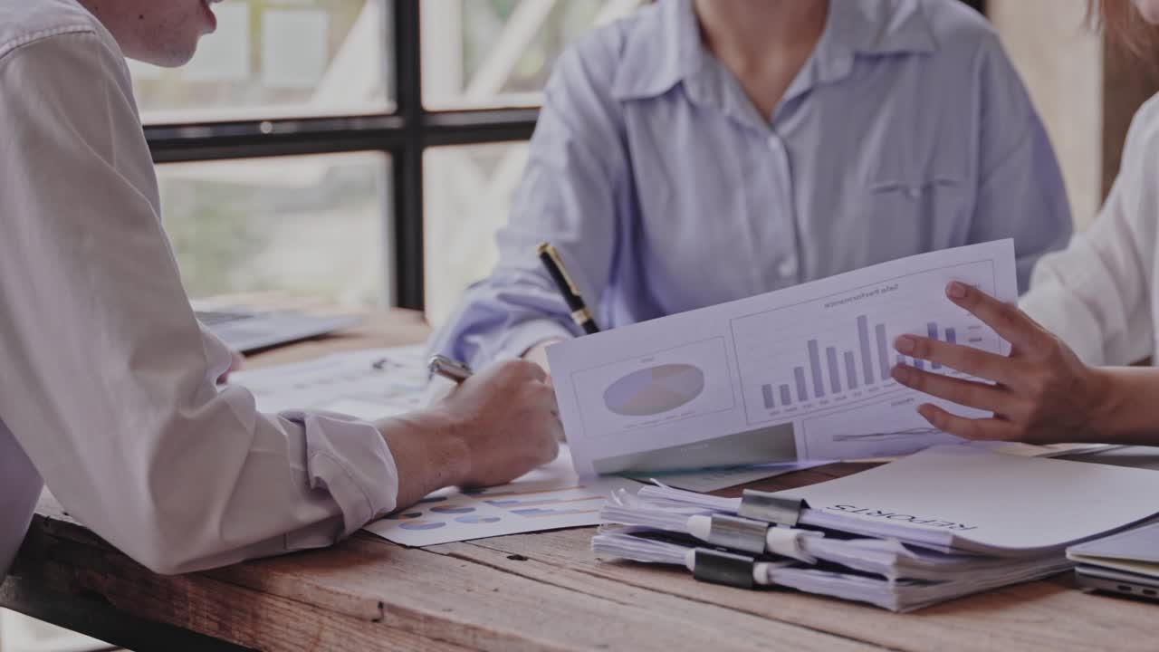 젊은 아시아인들은 성공적인 프로젝트를 위해 서로 박수를 치며, 창의적인 사무실에서 일하면서 똑똑한 캐주얼 옷을 입고 웃고 있습니다.