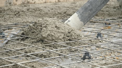 slow motion concrete oozing out concrete pump hose, close up