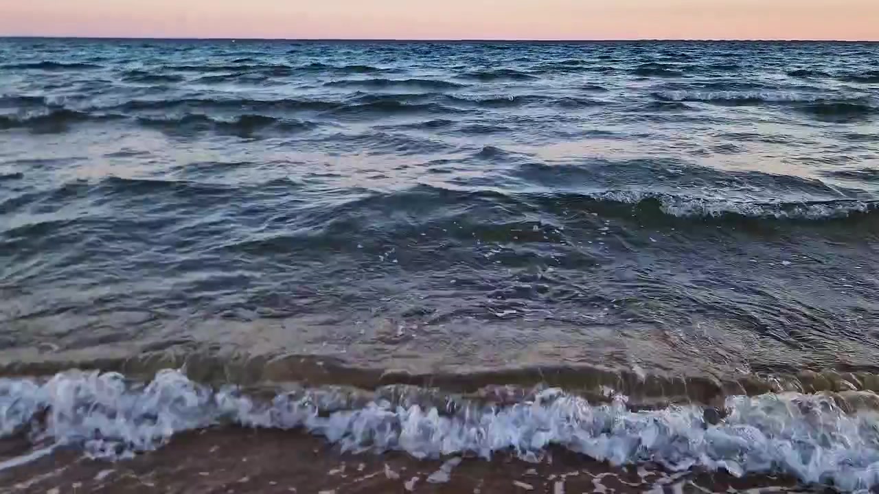 Спокойные морские волны мягко накатывают на испанское побережье на закате, идеально подходит для тем путешествий и отдыха.