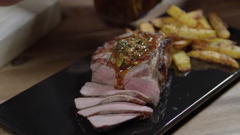 Echando-Salsa-Chimichurri-A-Las-Rebanadas-De-Carne-Con-Papas-Fritas