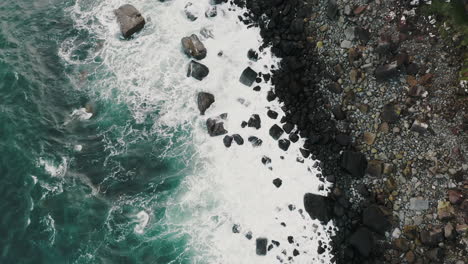 Incline-Hacia-Arriba-La-Vista-Aérea-De-Las-Olas-Del-Mar-Rompiendo-En-La-Costa-Bajo-Impresionantes-Acantilados-Rocosos-De-La-Isla-De-La-Isla-De-Skye,-Escocia,-Reino-Unido