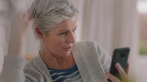 Mujer-Madura-Feliz-Teniendo-Video-Chat-Usando-Una-Abuela-De-Teléfono-Inteligente-Disfrutando-De-Una-Conversación-Con-Una-Familia-Que-Comparte-El-Estilo-De-Vida-Charlando-Por-Teléfono-Móvil-Con-Sus-Nietos-Relajándose-En-Casa-4k