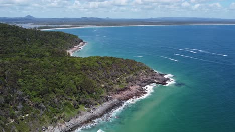 flying over peninsula showing rocky beach and jet skis below