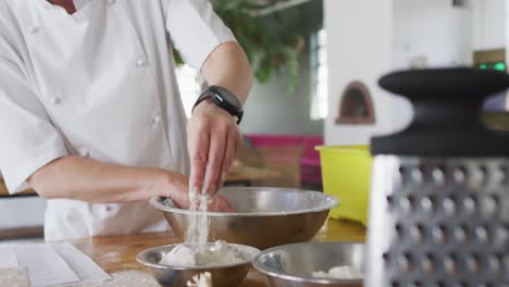 caucasian female chef adding flour into a bowl