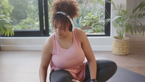 meditating with headphones, plus size woman practicing mindfulness at home