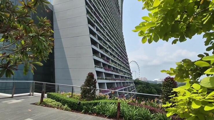 Architettura moderna delle torri dell'hotel Marina Bay Sands incorniciate dalle foglie verdi degli alberi a Singapore