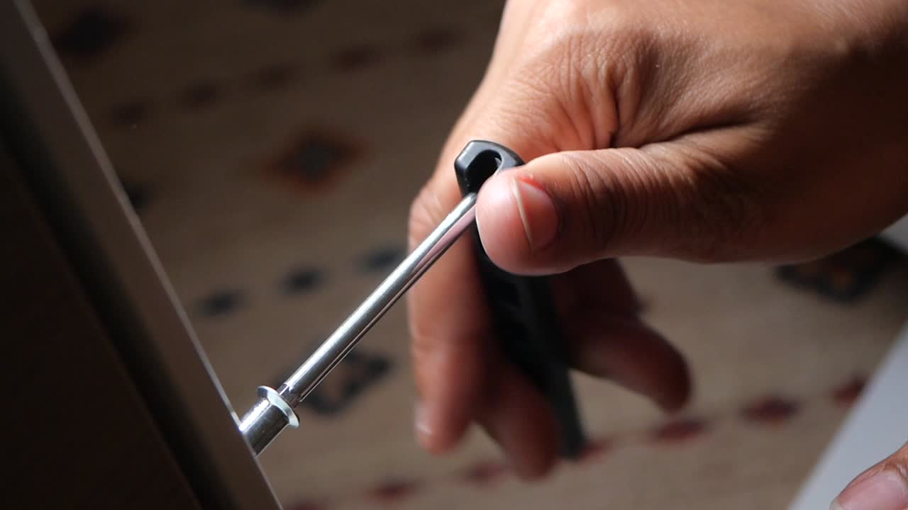 Person using a screwdriver to install or repair something