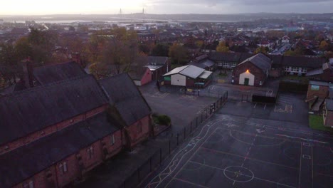 descending early morning school playground aerial view industrial town churchyard at sunrise