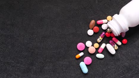 assorted pills and capsules scattered from a bottle