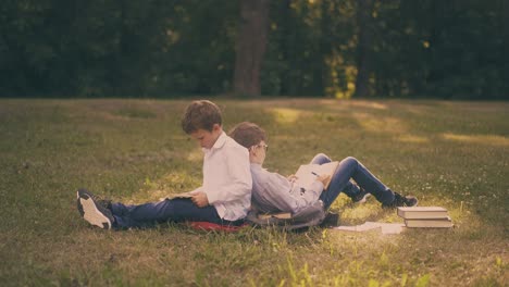 school friends read textbooks on lawn grass after lessons