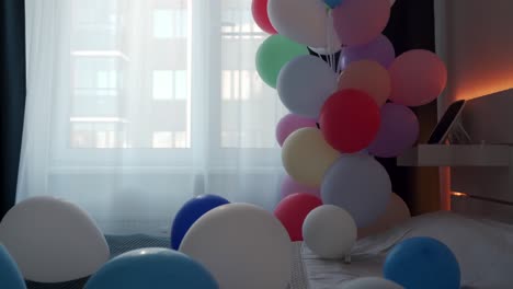 día de san valentín, cita romántica y concepto de vacaciones - cama decorada con globos de colores en el dormitorio.