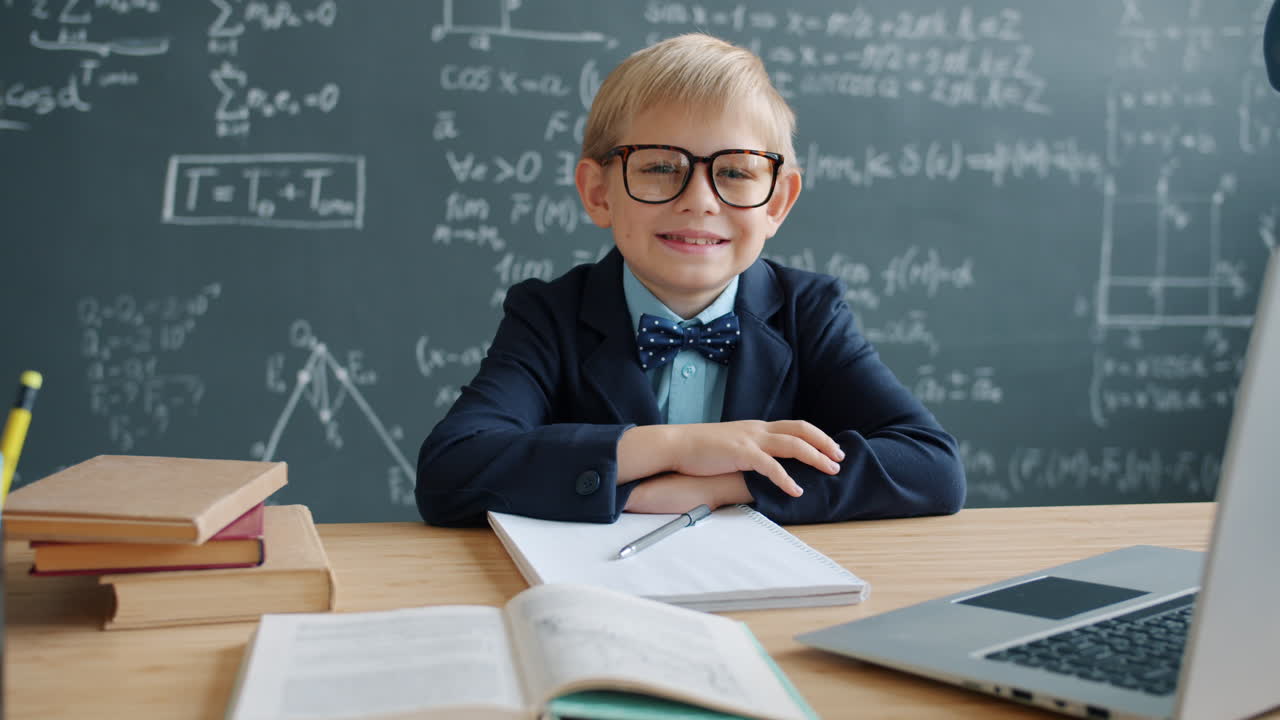 Smiling Boy Student in a Classroom with Laptop
