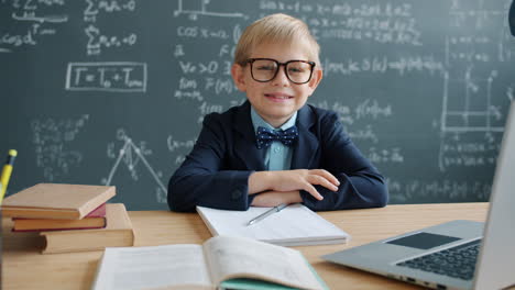 smiling boy student in a classroom with laptop